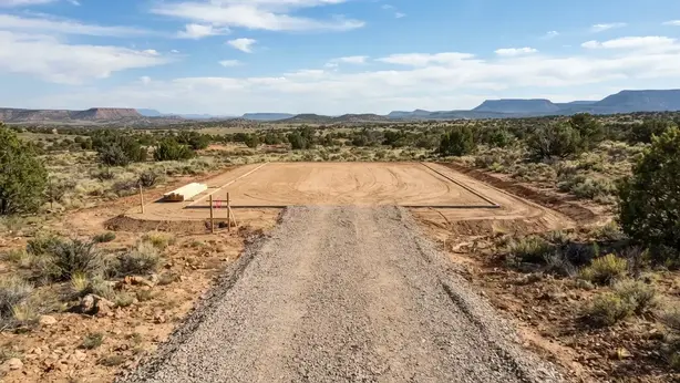 Completed rural house pad connected to a graded driveway and drainage system in Apache County Arizona