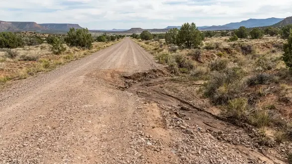 Apache County Arizona gravel road with a localized washout near a drainage crossing
