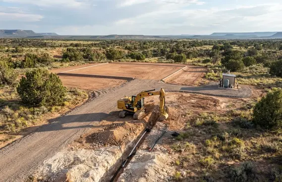 Rural house pad coordinated with utility trenching, private well, driveway, and site improvements in Apache County Arizona