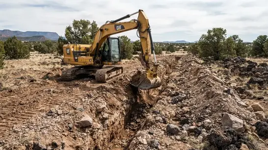 Utility trench excavation through rocky and caliche-rich ground on a rural Apache County Arizona property