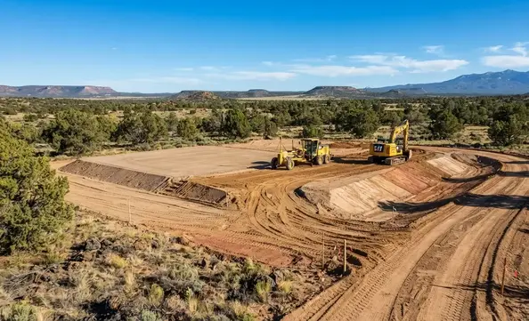 Rural Apache County Arizona property being professionally graded around natural high-desert terrain and elevation changes