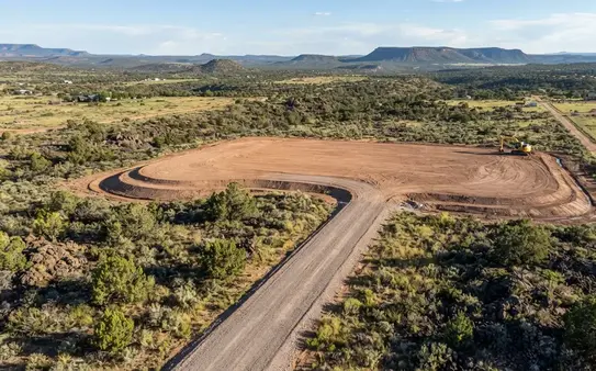 Completed rural land development project with excavation, grading, drainage improvements, and access road in Apache County Arizona