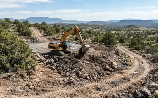 Excavation project showing rock excavation, grading work, and rural driveway construction in Apache County Arizona