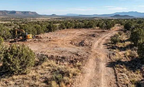 Cleared Apache County rural property showing a future homesite, access road, drainage area, and areas prepared for continued site development